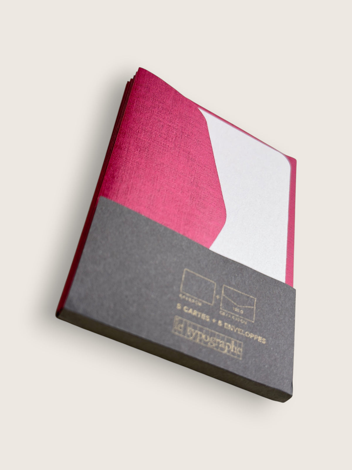Set of magenta and white letterpress mini cards in their grey paper band, printed in gold in Brussels.