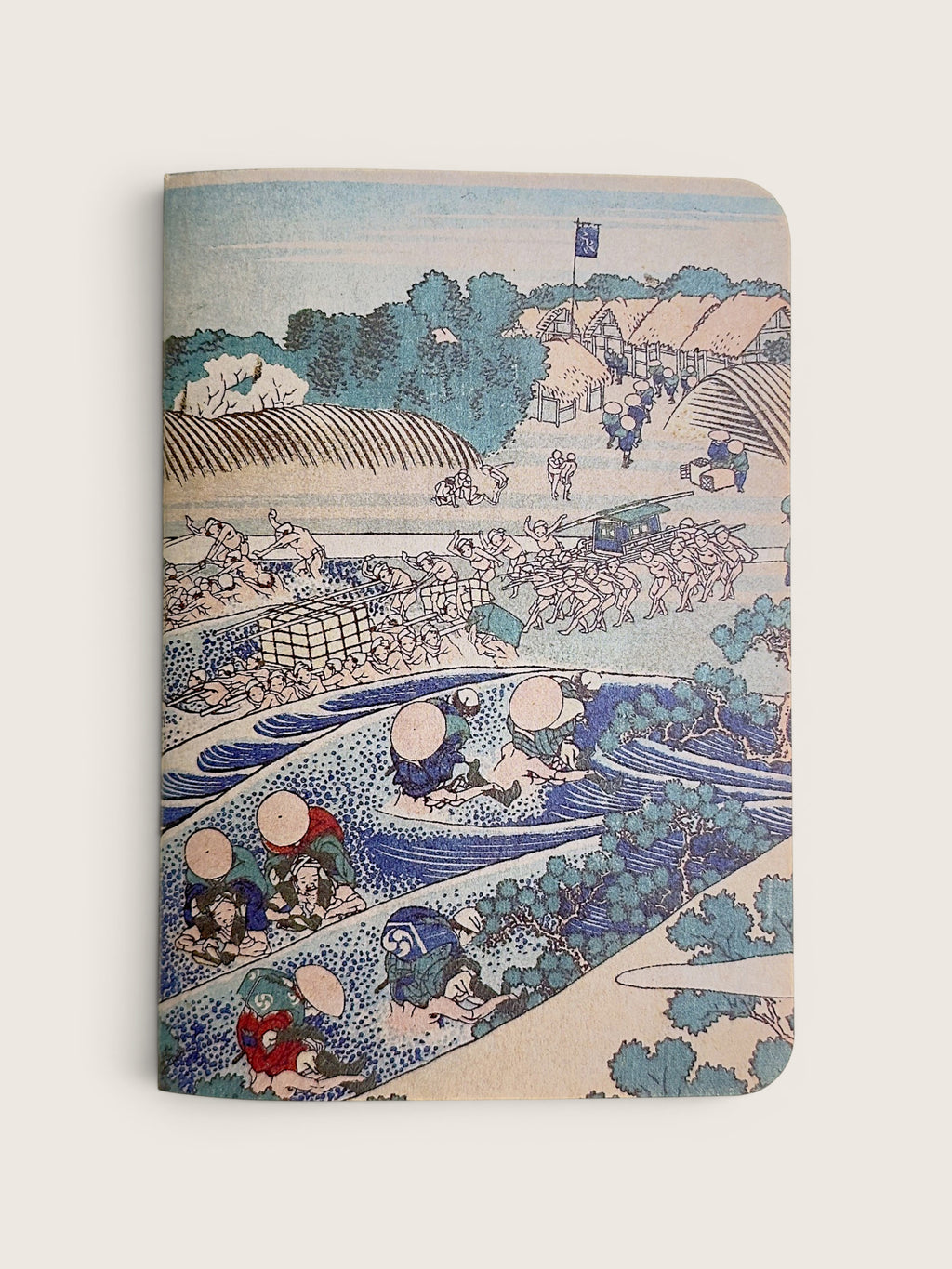 A hardcover notebook featuring a classic Japanese ukiyo-e woodblock print of a river scene with figures, boats, and buildings, shown against a light beige background.