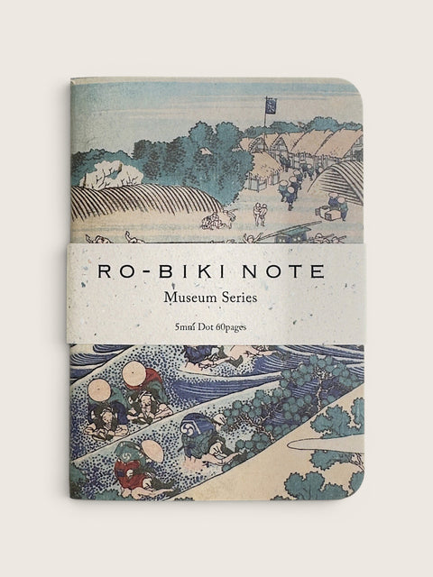 A notebook with a vintage Japanese ukiyo-e woodblock cover design, featuring the text 'RO-BIKI NOTE Museum Series' wrapped around the center, photographed against a neutral light beige background.