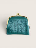 A small teal leather kiss-lock wallet with embossed floral designs and the brand name 'zucchero' on the front, set against a solid light beige background.