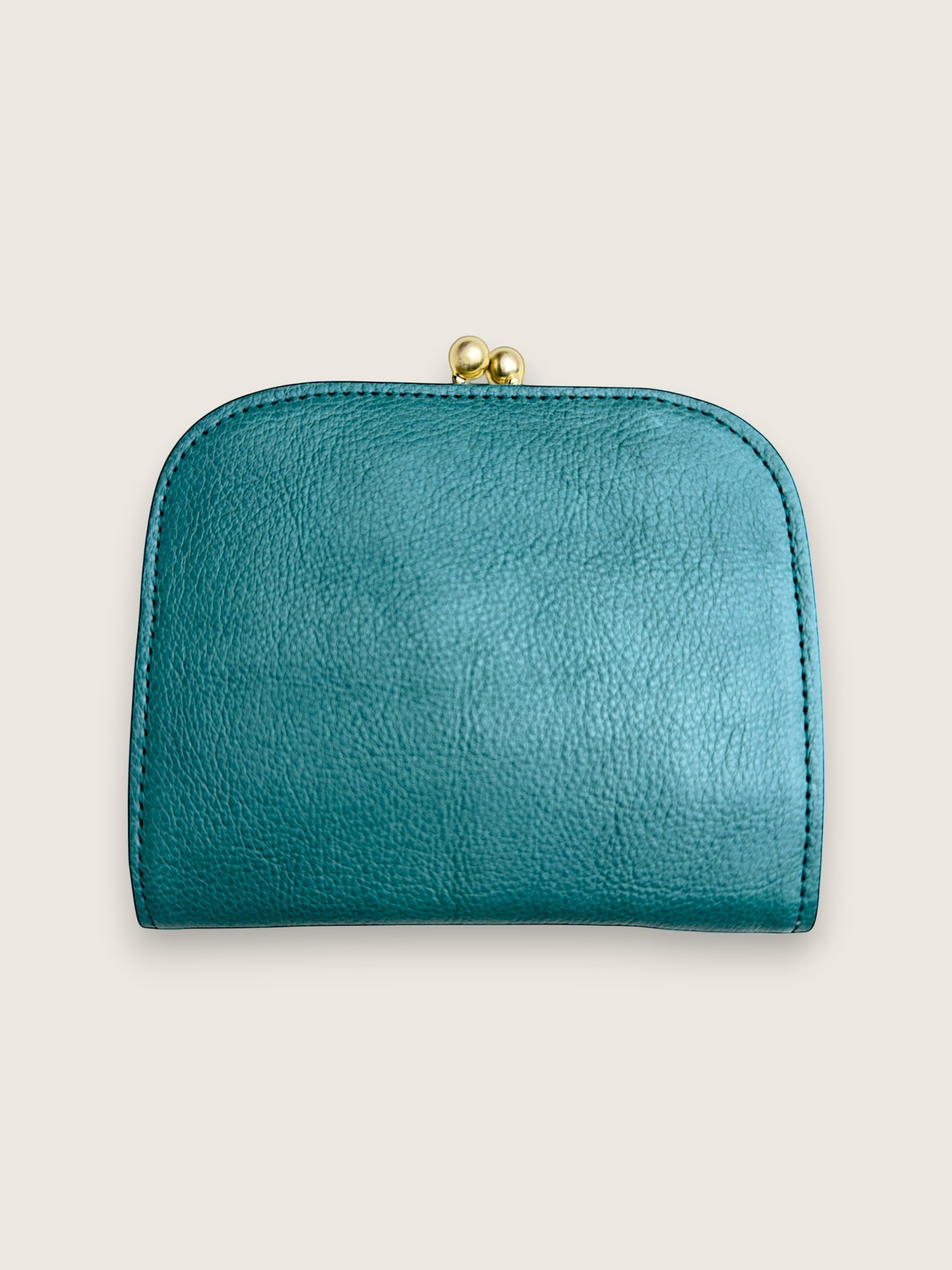 A small teal leather coin purse with a gold-tone clasp closure, shown against a solid light beige background.
