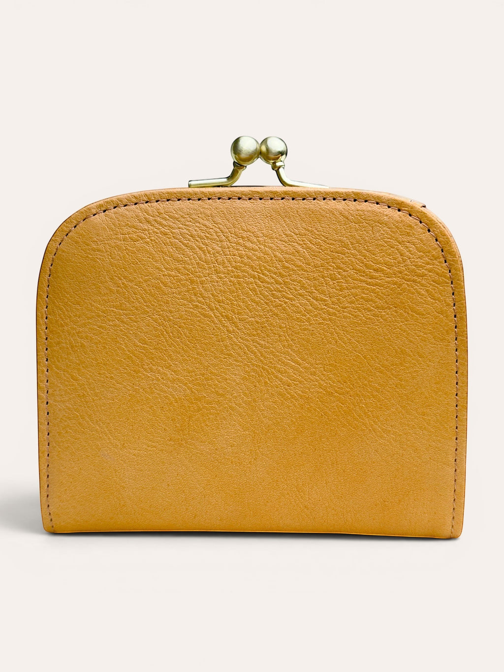A small mustard yellow leather wallet with a gold-tone metal clasp closure, shown against a plain light beige background.