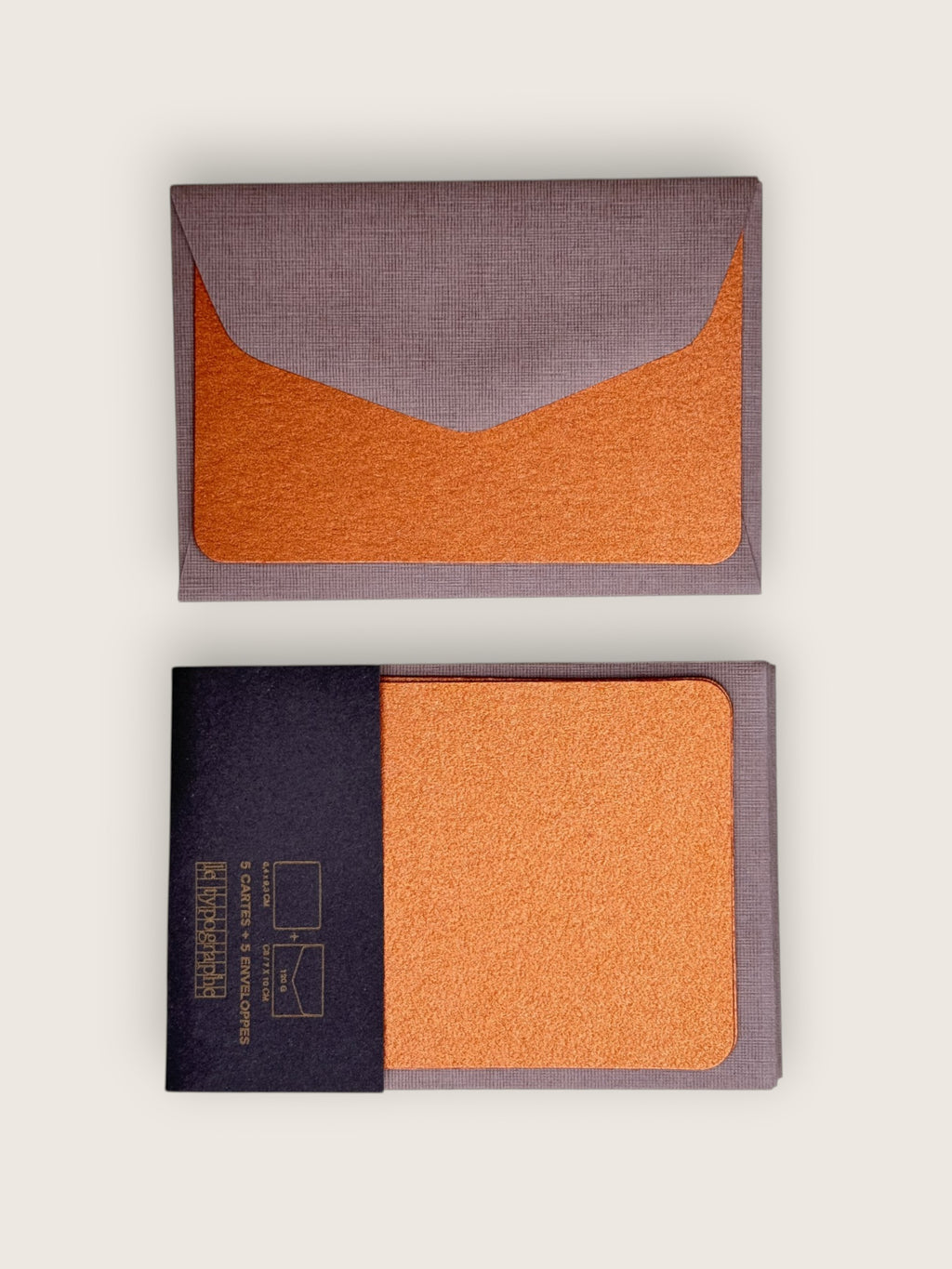 Two rectangular fabric pouches or card cases shown on a light neutral background, one closed with a gray envelope flap over an orange insert and one open with a dark navy band and orange insert visible.