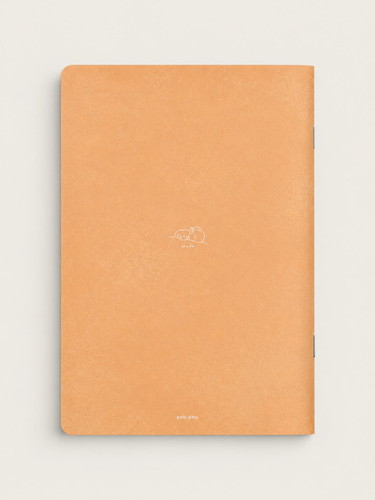 A peach-colored textured notebook with a minimalist white line drawing of a sleeping dog and the word 'dream' on the cover, shown against a light off-white background.