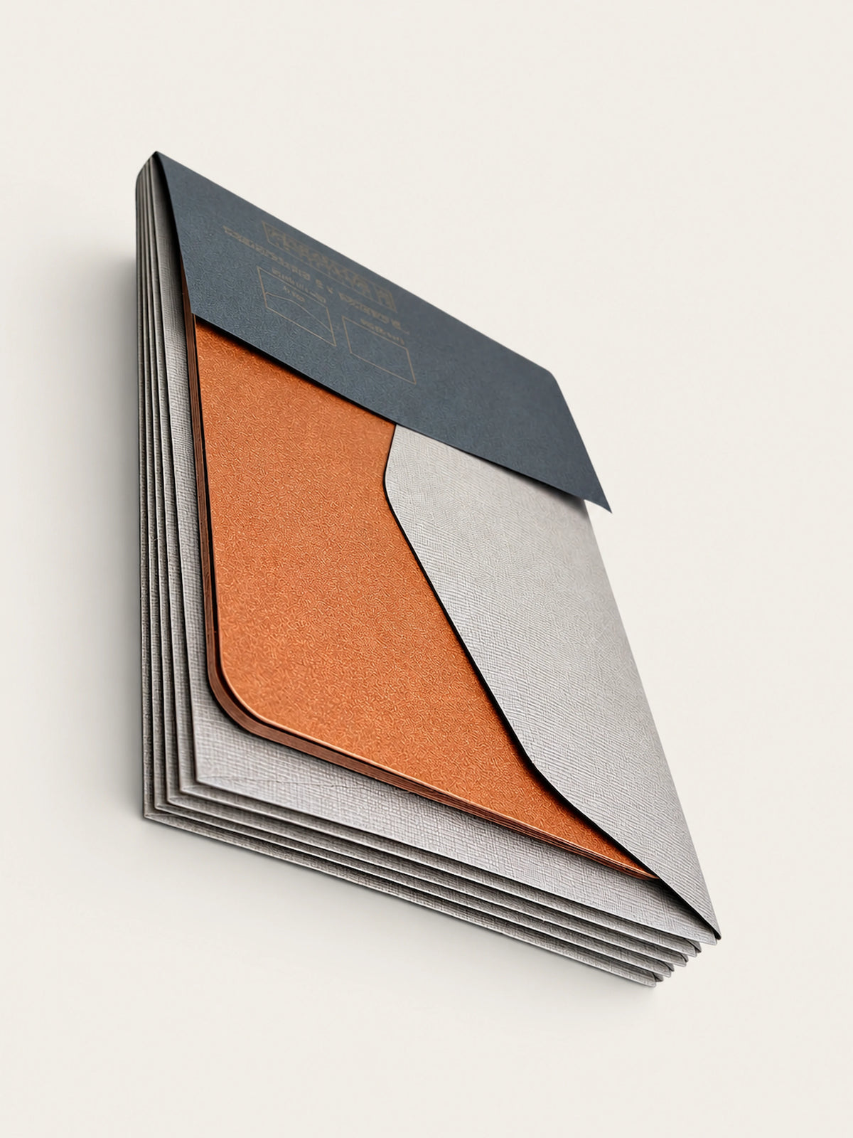 Corner detail of the set fanned out, layering barley envelopes, a copper card and the charcoal paper band.