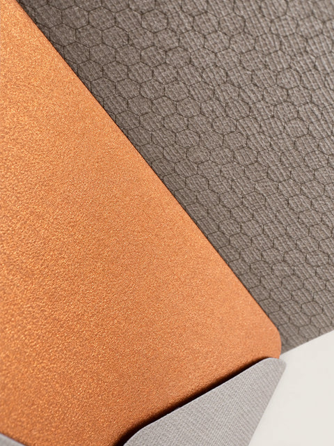 Close detail of a copper card resting on a barley envelope, showing the honeycomb pattern printed inside the envelope.