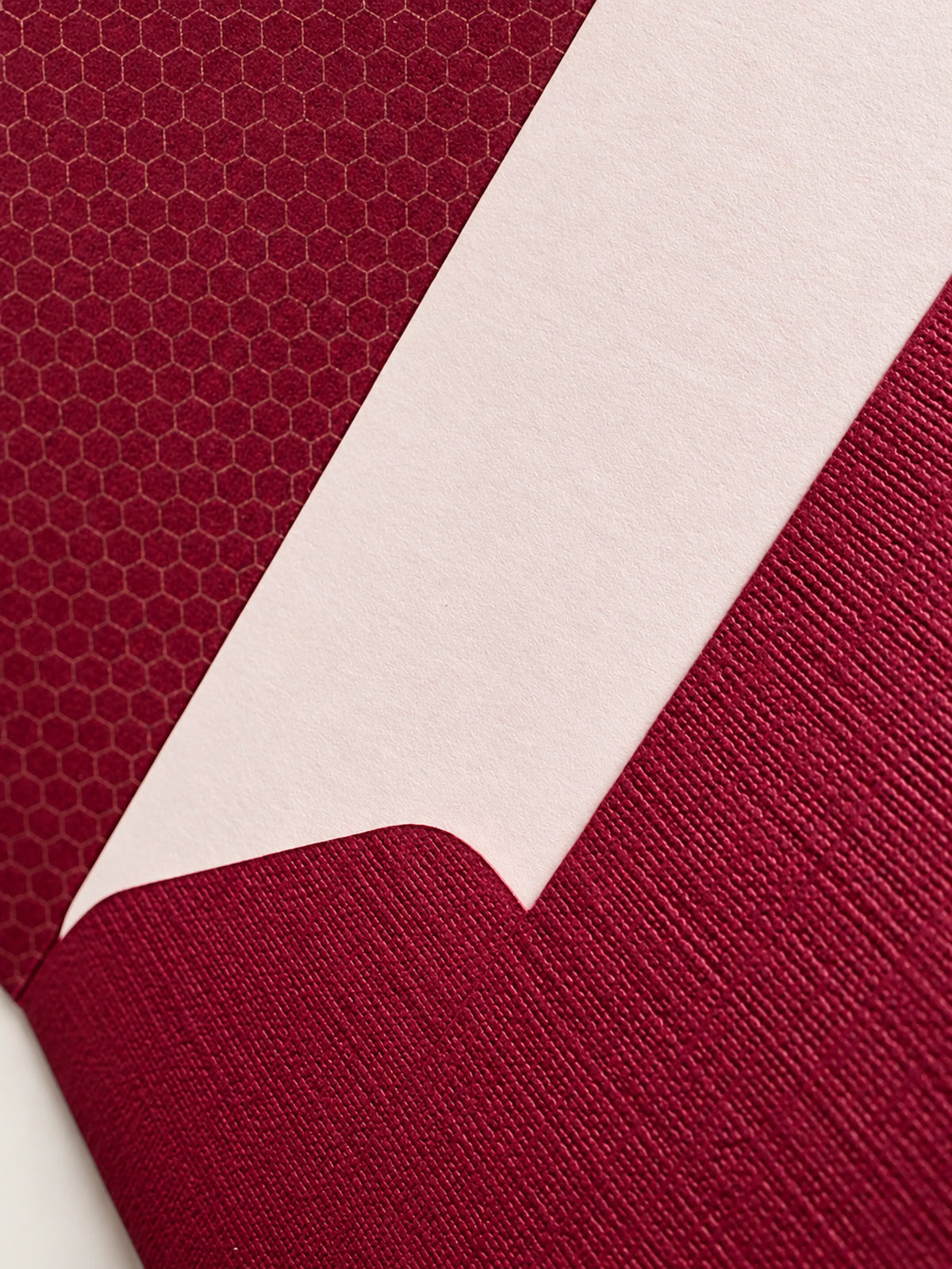 Close-up of textured burgundy envelope and pale peach card paper from Le Typographe