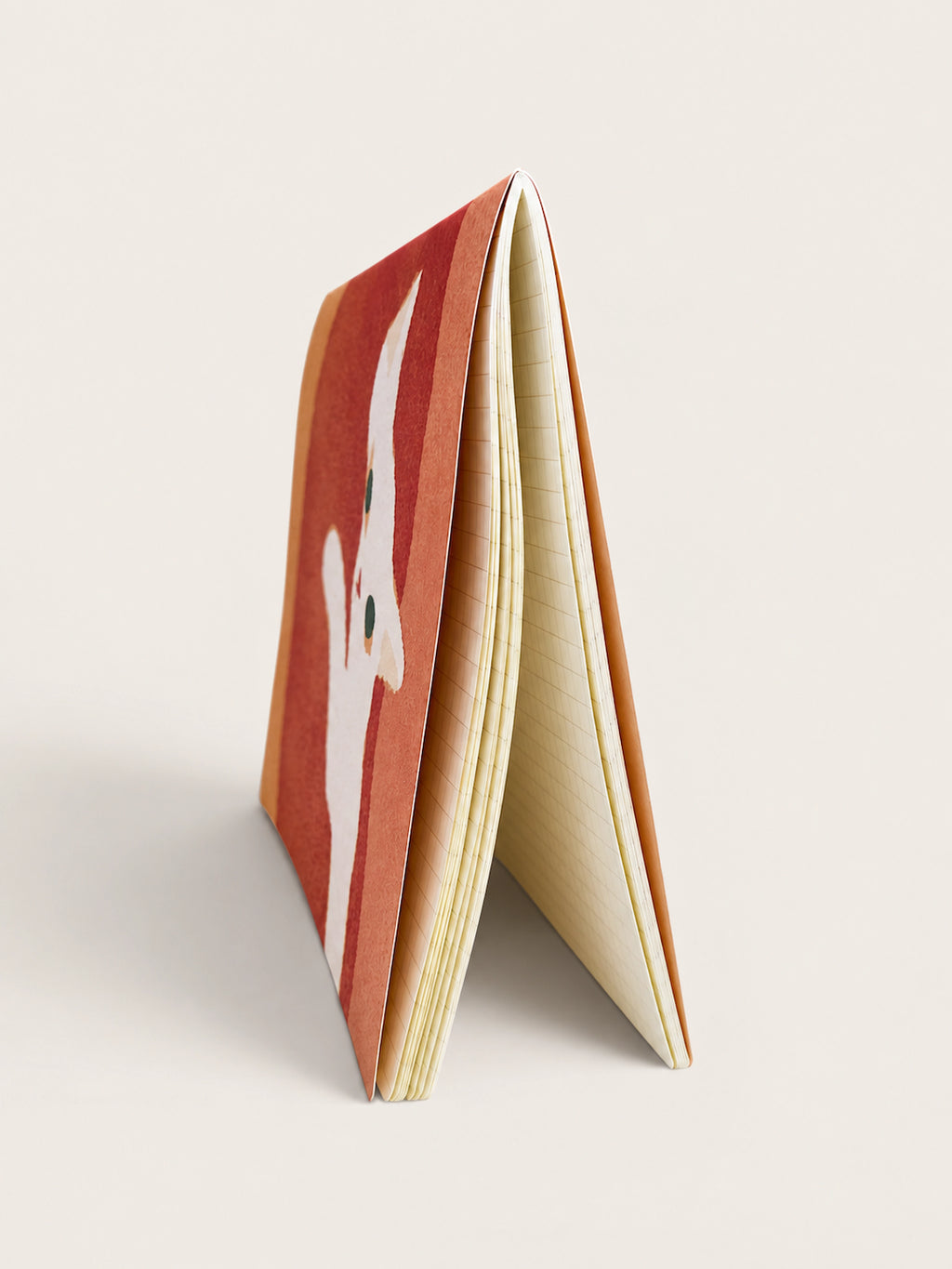 Side view of the White Cat A5 notebook standing open, showing its embossed cover and cream grid pages, made in Japan by RYU-RYU