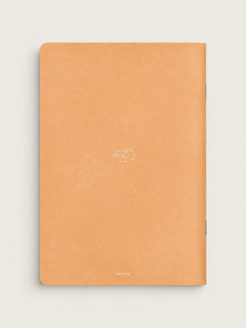 Back cover of the White Cat notebook by mula in soft apricot, with a small white line drawing of a sleeping cat and a stapled spine