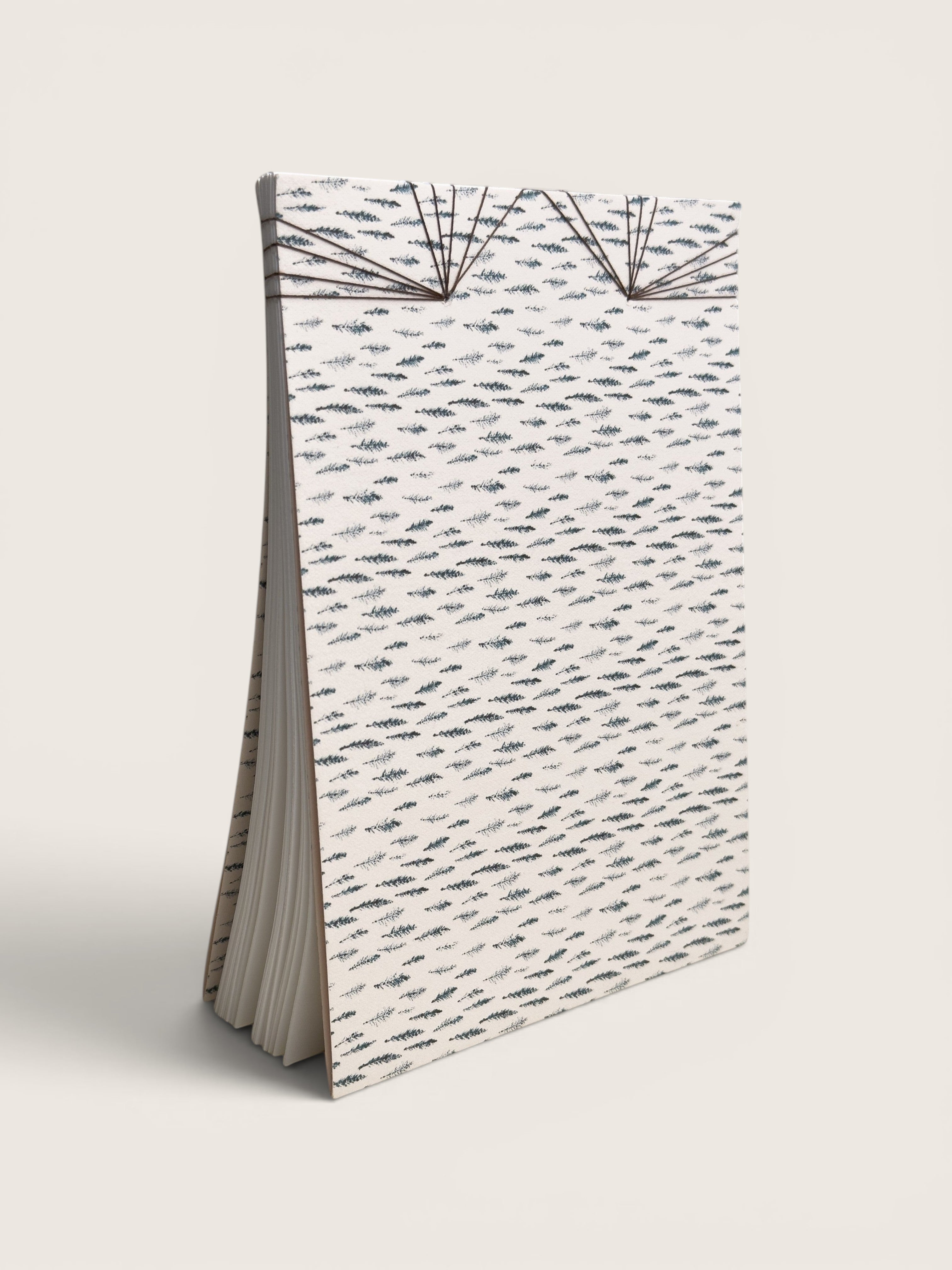 Ourooh A5 notebook featuring a white cover with black cypress sprig pattern and decorative Japanese-style fan binding.