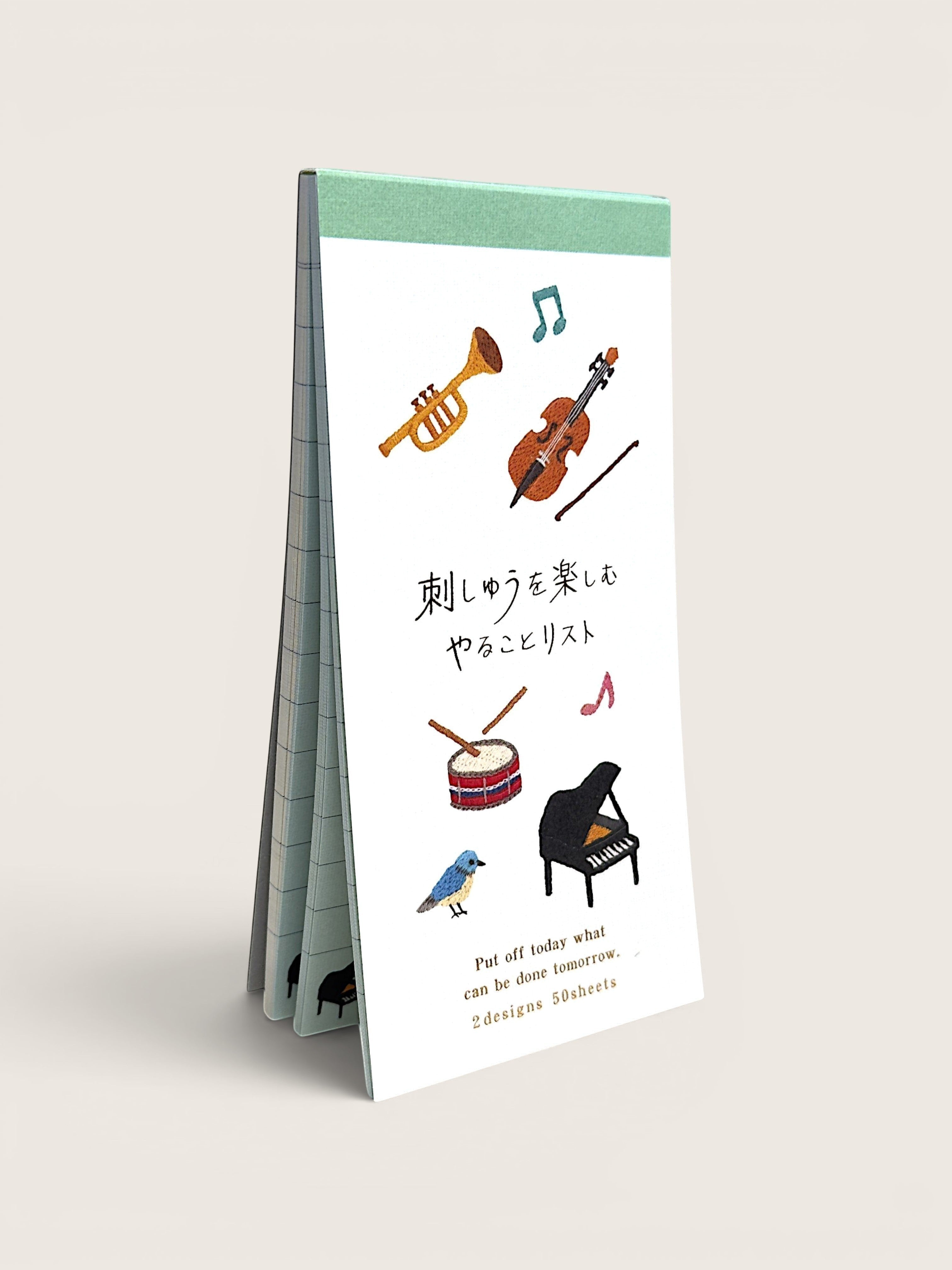 Ourooh Japanese to-do list pad featuring embroidered musical instruments and a blue bird on a green-bound paper block.