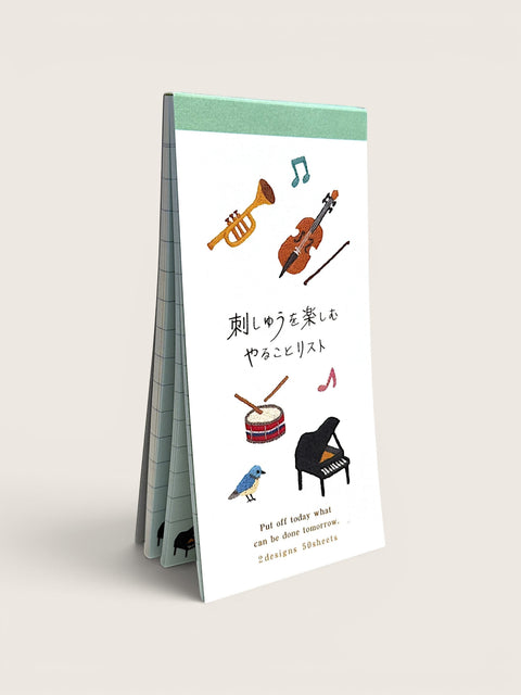 Ourooh Japanese to-do list pad featuring embroidered musical instruments and a blue bird on a green-bound paper block.