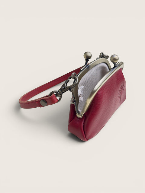 Ourooh Kanmi deep red cowhide leather mini pouch with a brass gamaguchi clasp, adjustable strap, and tree motif.