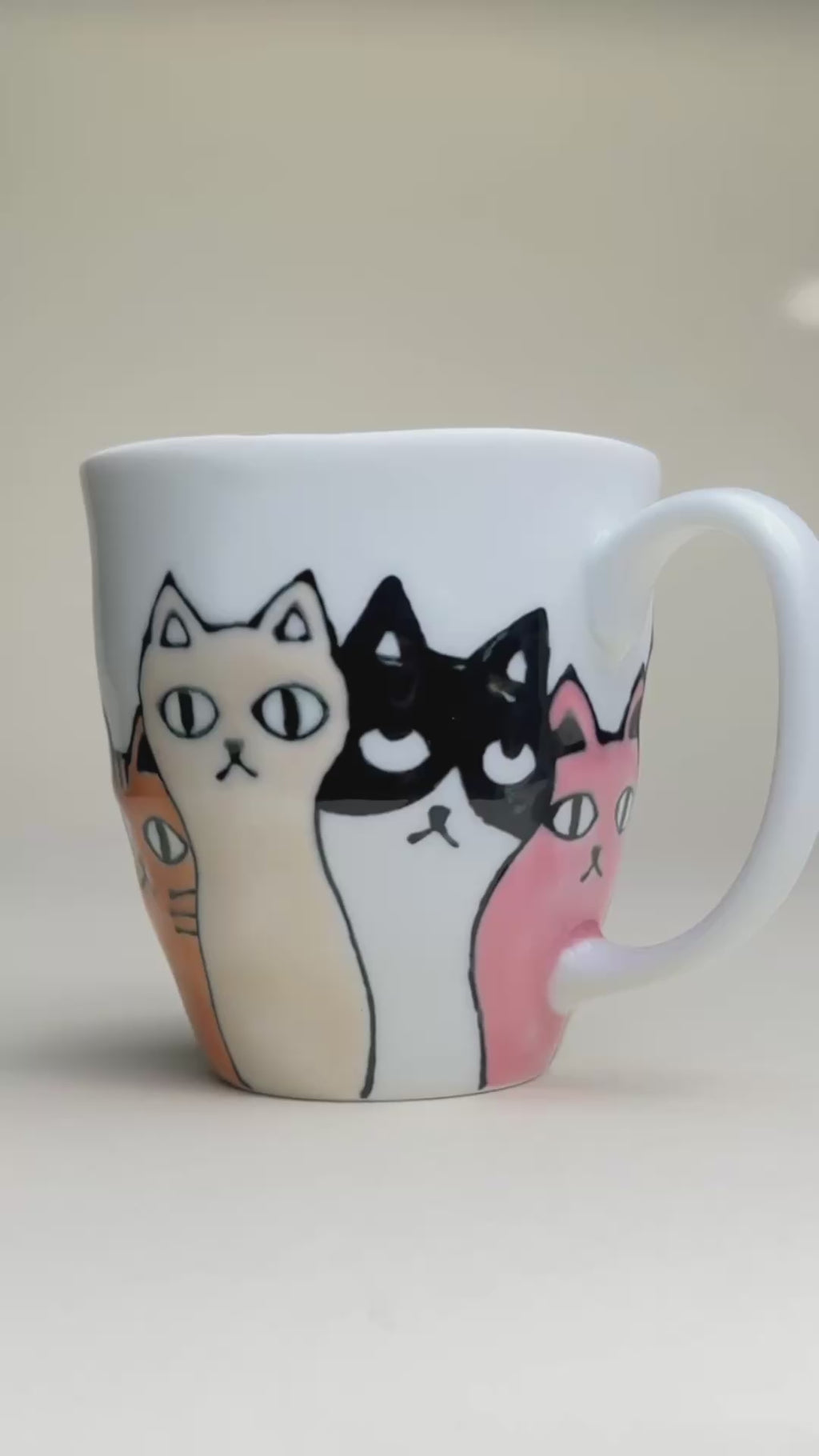 ceramic cat mug video showing the cats colours which are black, pink orang, and white and black, made in japan