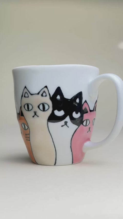 ceramic cat mug video showing the cats colours which are black, pink orang, and white and black, made in japan