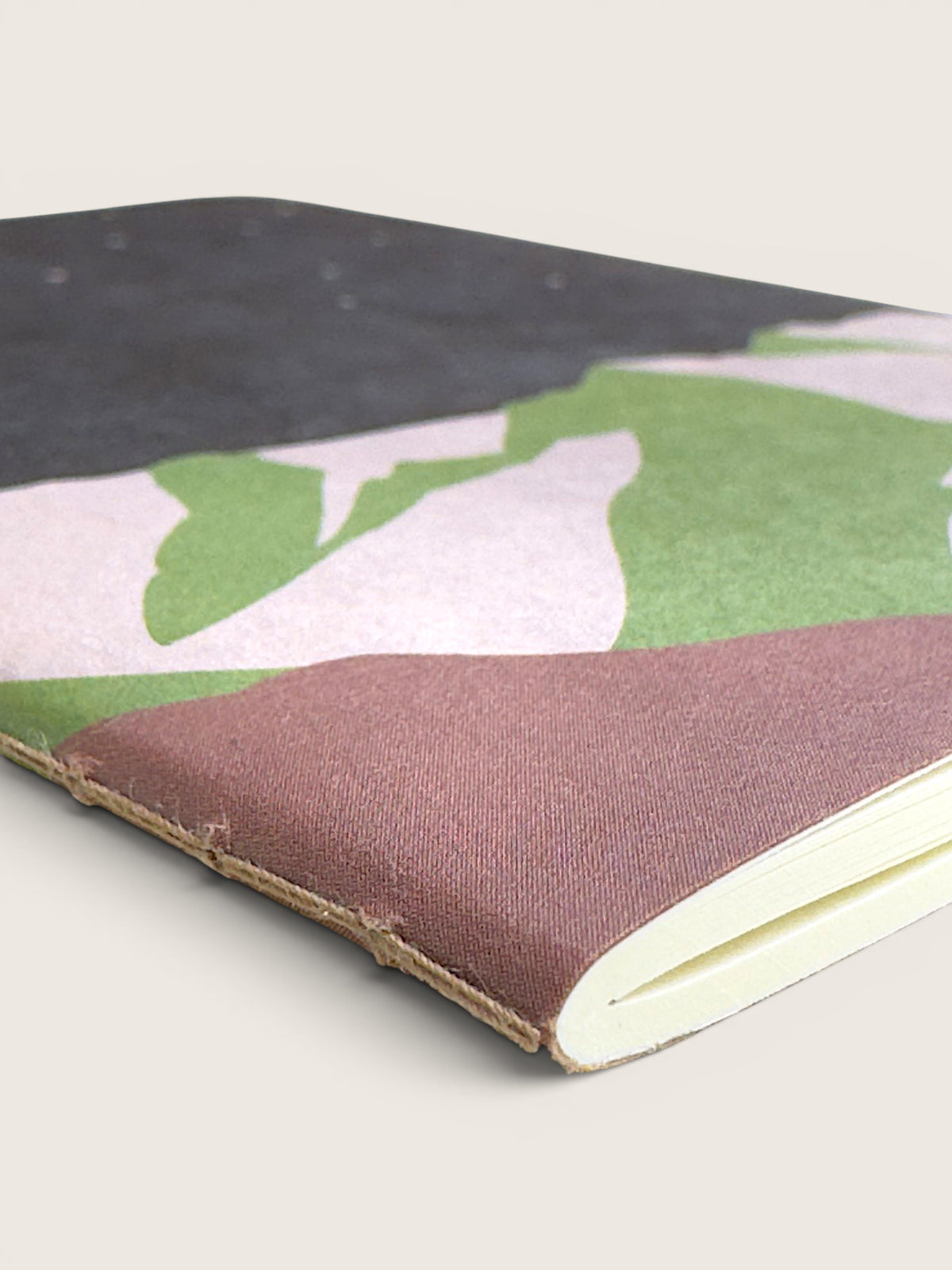 Detail of the Mountain Night RO-BIKI notebook showing the waxed cover, the binding and the cream pages.