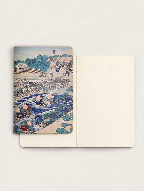 Japanese RO-BIKI NOTE Tokaido pocket notebook with traditional woodblock artwork, shown beside its open cream pages with 5 mm dot grid and visible thread stitching.